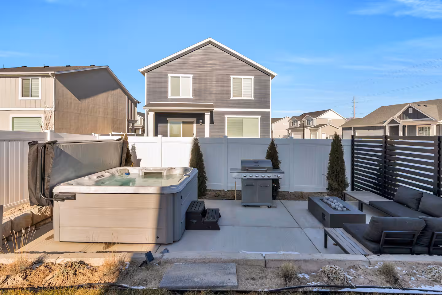 View of the backyard and patio with hottub and seating