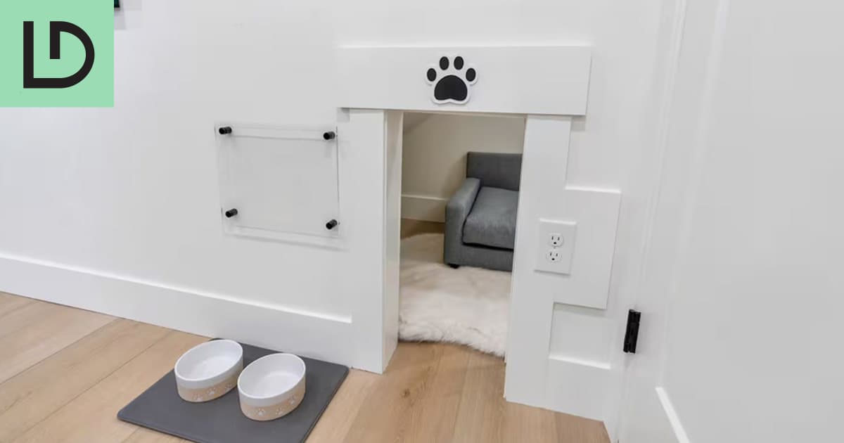 Small dog den with a dog bed and water bowls under the stairs at Luxe Den in Lehi